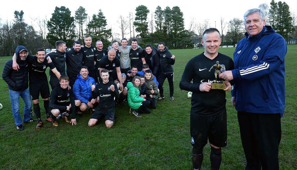 __Man of the Match__Bryan Tosh of Dervock receives his trophy from Wayne Glynn, Vice-Chairman of the Irish FA Junior Committee, as his team mates look on.jpg