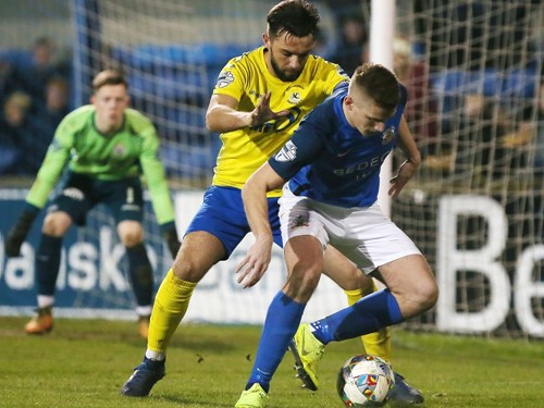 Andrew Mitchell shields the ball from Chris Hegarty.jpg