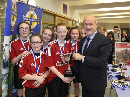 Alfie Wylie presents the trophy to Holy Cross College who were winners of the Year 8/9 section