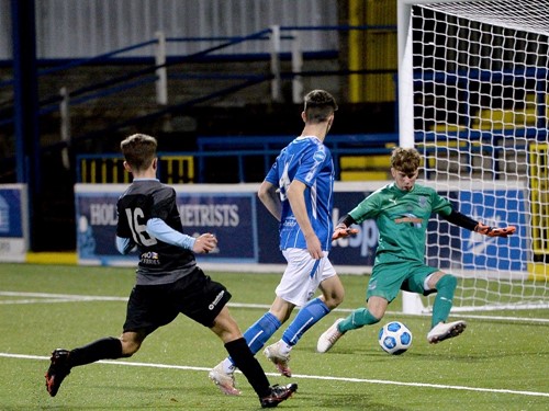 Coleraine's Kirk McLaughlin nutmegs the Ballymena stopper Mason Hume to make the score 3-1.jpg