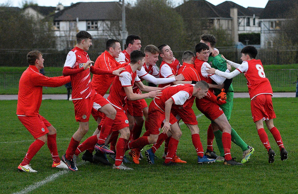 Cliftonville Strollers keeper Orann Donnelly is swamped by his team mates after securing a place in the semi final for the Reds.jpg