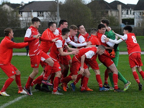 Cliftonville Strollers keeper Orann Donnelly is swamped by his team mates after securing a place in the semi final for the Reds.jpg