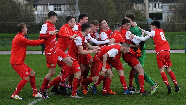 Cliftonville Strollers keeper Orann Donnelly is swamped by his team mates after securing a place in the semi final for the Reds.jpg 