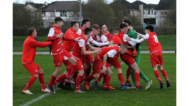 Cliftonville Strollers keeper Orann Donnelly is swamped by his team mates after securing a place in the semi final for the Reds.jpg 