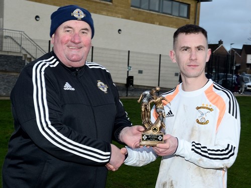 Irish FA Junior Committee member Davy King presents Harryvill Homers Andrew Steele with his man of the match trophy.jpg