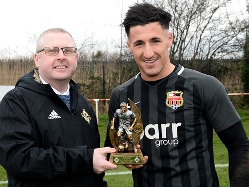Wayne Irvine of the Irish FA Intermediate Cup Committee presents the Man of the Match trophy to East Belfast's Daniel Purkis .jpg