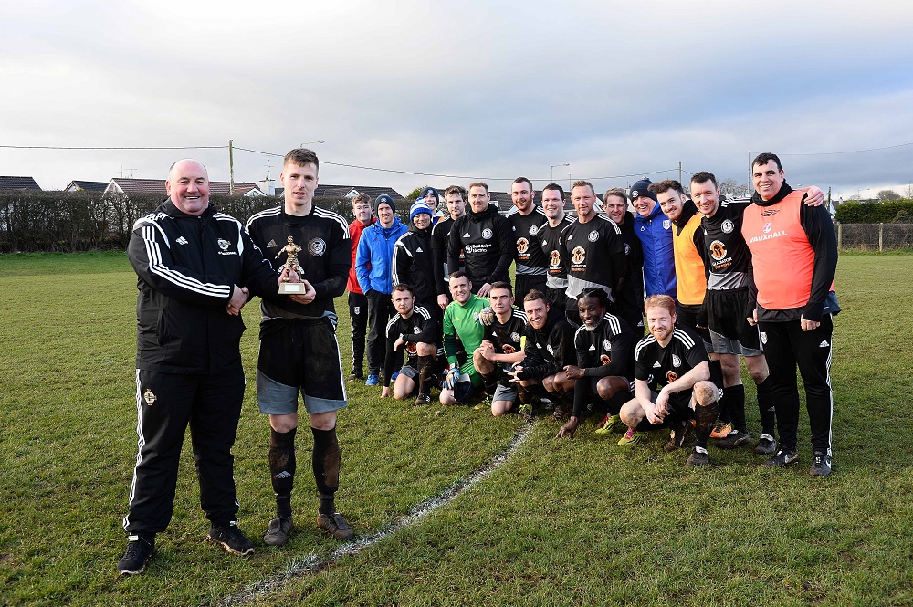 Man of Match Randal Reid with Davy King of IFA Junior Committee as Ahogill team look on (002).jpg